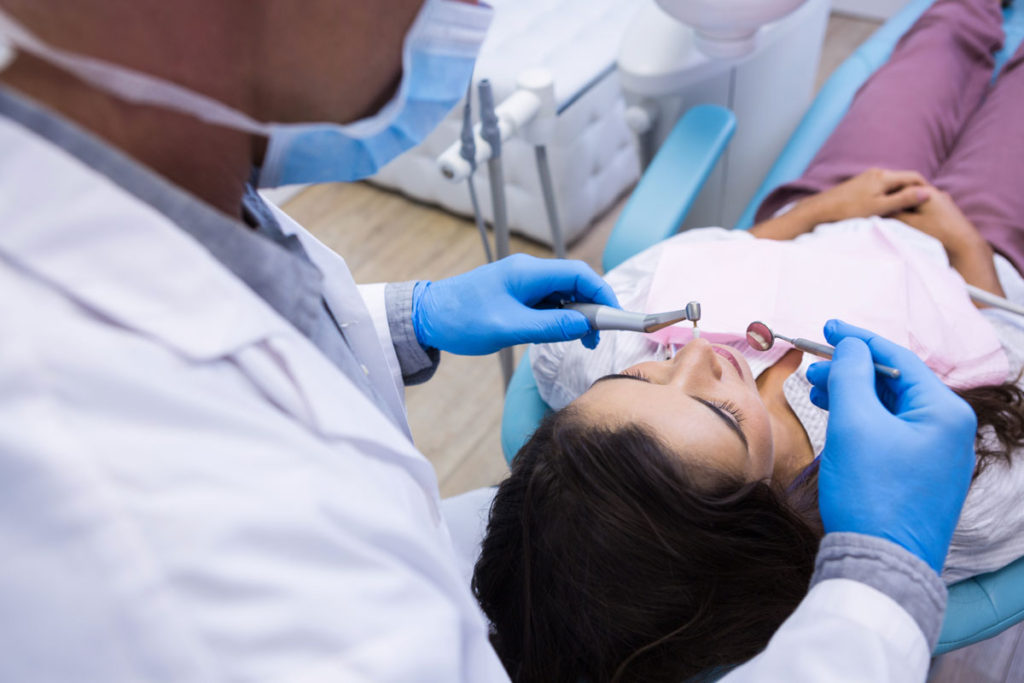 primul plan al dentistului care examineaza pacienta