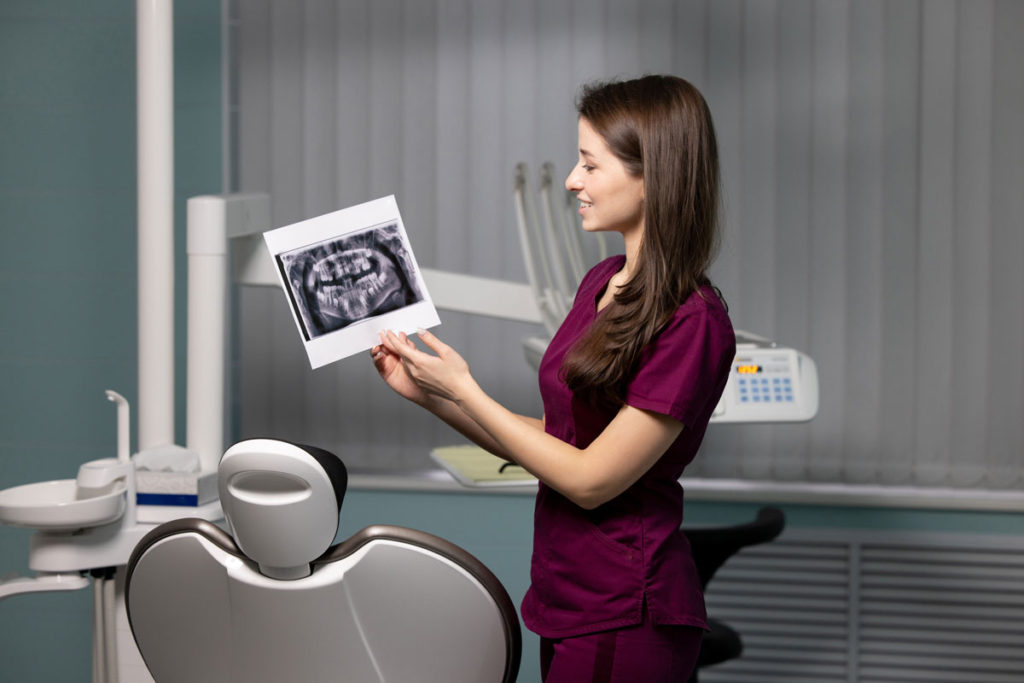 medic stomatolog analizand o radiografie dentara