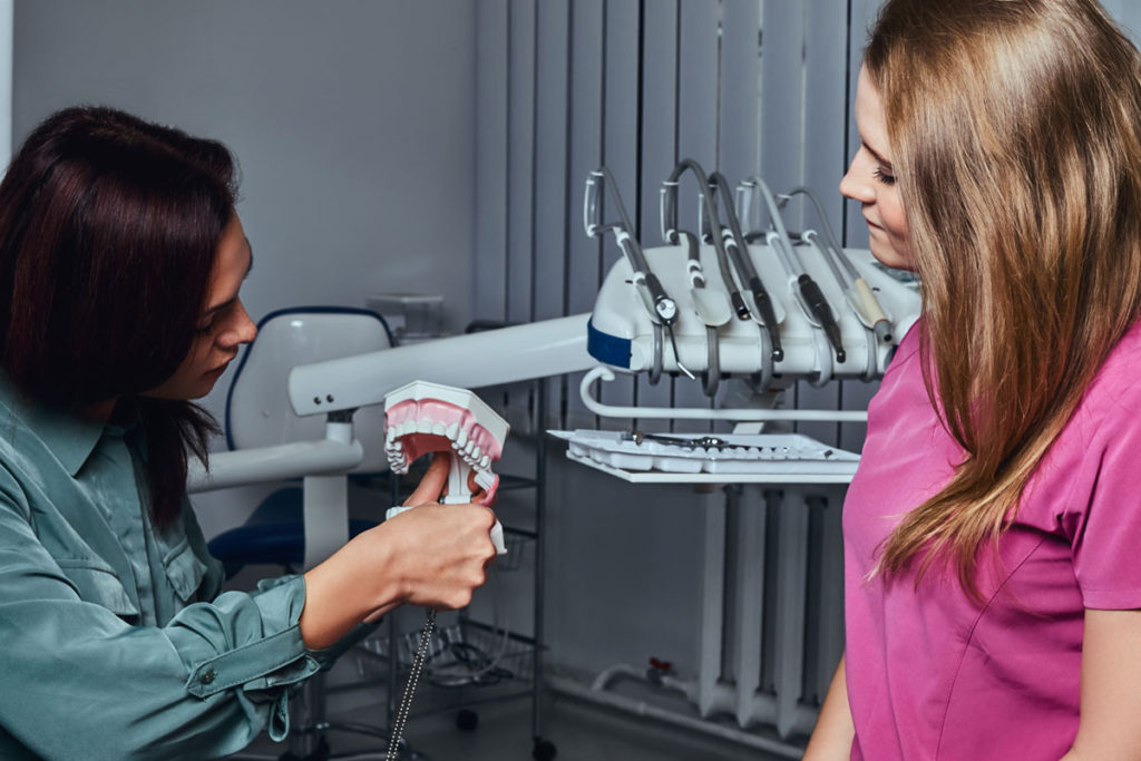 dentist care explica pacientei procedura de reconstructie cu pivot