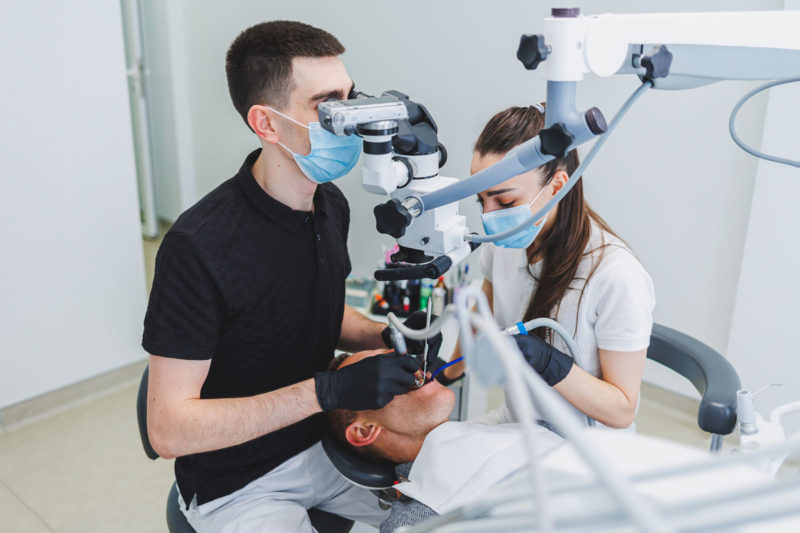 medic stomatolog si asistenta in timpul unei interventii de reconstructie dentara